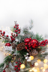 Beautiful Christmas background. Spruce branches with red decorations on a white background.