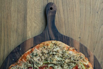 Homemade pizza on a round walnut board