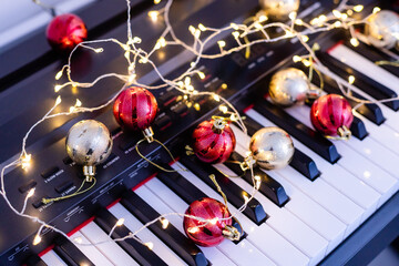 A colorful chain of lights lies on piano keys