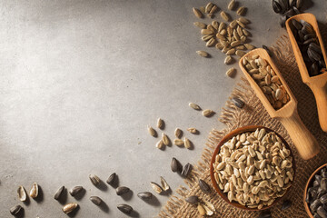Sunflower seeds in a bowl with cooking oil on concrete background. Concept of food industry.