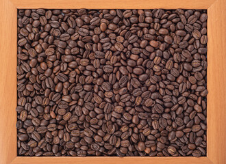 Coffee beans in a wooden frame, abstract background.