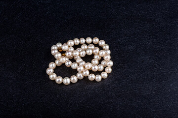 Natural pearl beads on a stone surface.