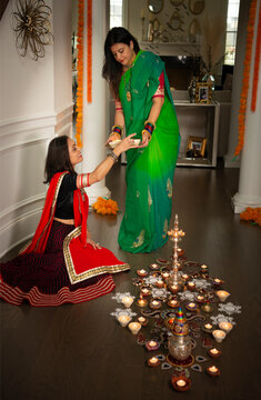 Women arranging Diwali lamps 