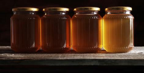 Barattoli di miele isolati su sfondo scuro.