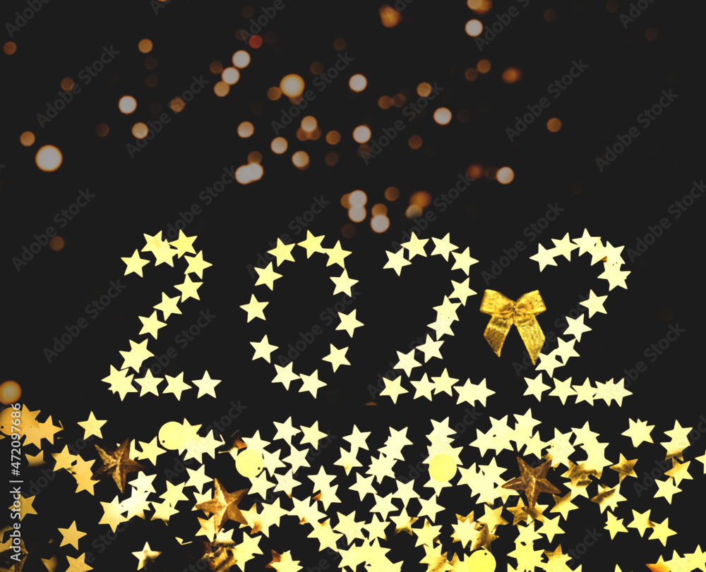 Poster festive dark background with gold sparkles and digits of 2022 . new year 2022 concept. creative copy