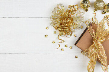 Flat Lay Christmas Concept. gold presents and ornaments with copy space on rustic white boards.