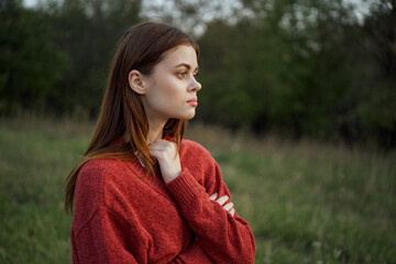 woman in a red sweater outdoors in a field walk