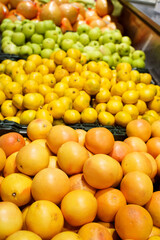 Grapefruit, lemons, apples and other fruits on the counter in the hypermarket