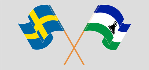 Crossed and waving flags of Sweden and Kingdom of Lesotho