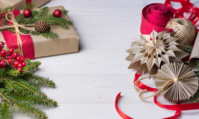 Flat lay with New Year, gift, red berries , ribbons. Craft paper for wrapping gifts and making diy homemade Christmas decorations ,stars. 