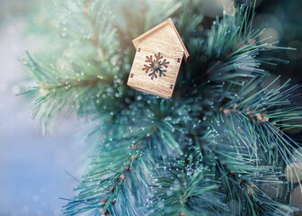 Fototapeta na wymiar Christmas ideas for greeting cards. A little toy house on the fir tree.