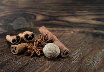 Natural spices. Fragrant anise star and nutmeg on a wooden background with cinnamon sticks