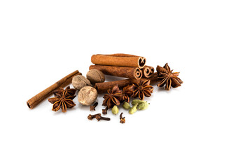 Nutmeg, cinnamon sticks, anise star, cloves and cardamom on a white background