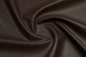 brown artificial leather with waves and folds on PVC base