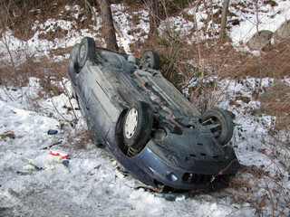 Ice and snow alert on the slippery road. Car crashed and overturned on the road in winter time. Car...