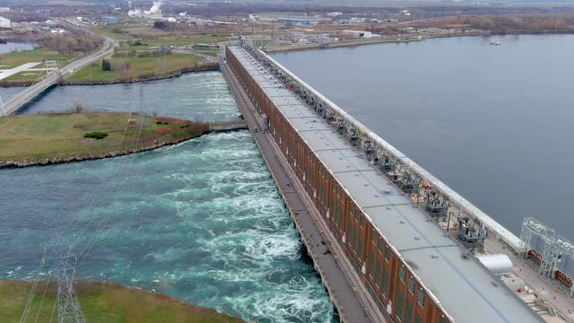 High quality, 4K aerial view of a hydroelectric generating station and distribution power lines.