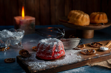 mini red velvet puddings with vanilla puddings with icing sugar whisk and lemon slices dark food style