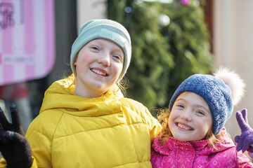 Two little sisters smiling sincerely while walking.