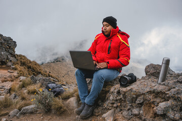 Male photographer working on a laptop outdoors in a camping