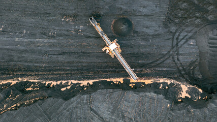 Territory of the coal terminal with coal dumps and a regenerator. loading and unloading of coal by excavators and belt conveyors. coal reserves at thermal power plants. View from above