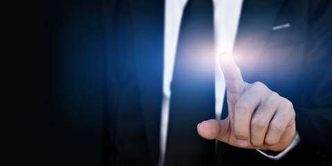 Businessman hand touching virtual screen on dark background with copy space