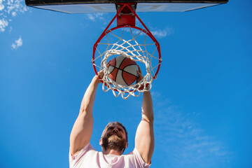 cheerful man player throw basketball ball through basket, motivation © Olena