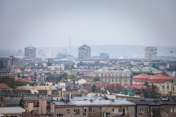 Obraz premium Skyline of New belgrade, or novi beograd, in Serbia, since from Zemun, with bruatlist residential skyscraper towers blurred due to an autumn foggy rain. Novi beograd is business district of Belgrade