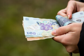 Selective focus on detail of LEI banknotes. Counting or giving Romanian LEI banknotes. World money concept, inflation and economy concept