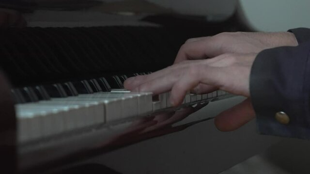 Playing gran piano chords closeup hands