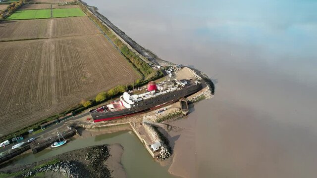 Moored TSS Duke of Lancaster in rural landscape, aerial fly away shot