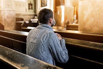 The man is praying in the church. Religious concept, light of spiritual state