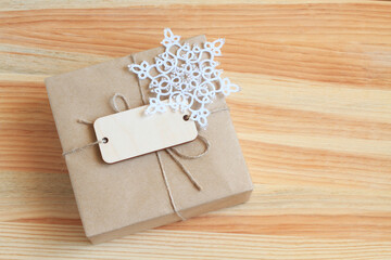 The box, wrapped in rough paper and tied with a rough rope, lies on a wooden table. View from above. Closeup