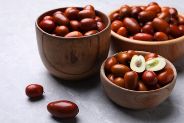 Fresh Ziziphus jujuba fruits with wooden bowls on light table