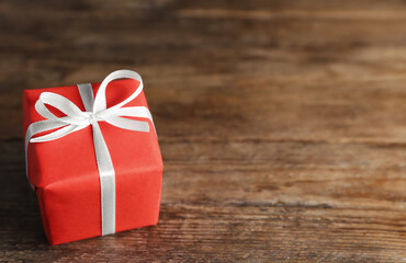 Beautiful gift box on wooden table, closeup. Space for text