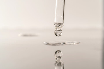 The texture of serum or oil with a pipette on a grey background.