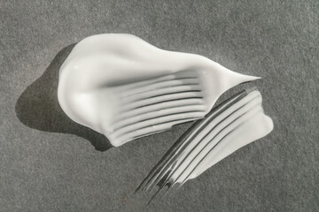 The texture of the white cream on a gray background.