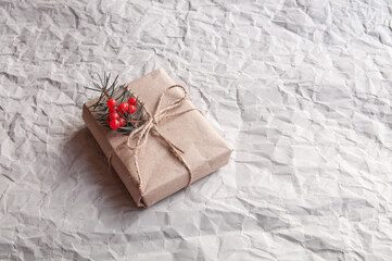 Gift box christmas tree leaves with red berries on a gray background