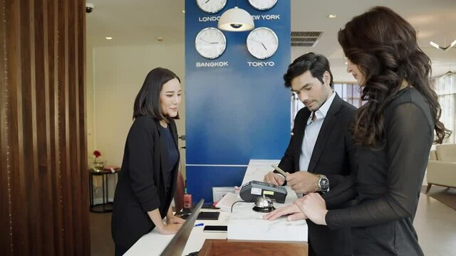 The guest is using a credit card with the edc machine to pay for services in the hotel lobby.
