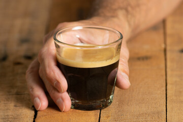 Man´s hand grabbing a glass of coffee