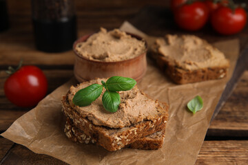 Fresh bread with delicious meat pate and basil served on wooden table, closeup