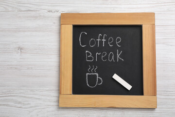 Blackboard with phrase Coffee Break and piece of chalk on white wooden table, top view
