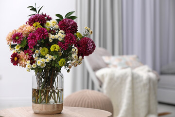 Bouquet of beautiful chrysanthemum flowers on table in room, space for text