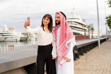 Businesswoman taking selfie with Arab man