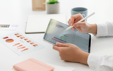 Cropped shot of hand using portable tablet analyzing business graph.