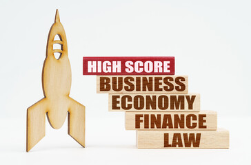 Obraz premium On the white surface there is a wooden rocket and planks, on the red plaque the inscription - High Score