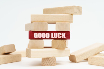 On the white surface there is a ruined tower made of planks, on a red plaque there is an inscription - Good Luck