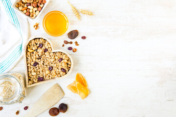 Top view of a heart shaped bow full of crunchy granola. Healthy eating concept. Copy space.