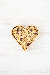 Top view of a heart shaped bow full of crunchy granola. Healthy eating concept.