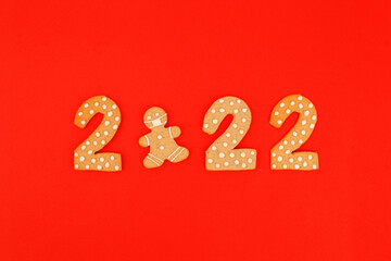 Happy New Year's, Christmas set of numbers 2022, gingerbread man in face mask from ginger biscuits glazed sugar icing decoration on red background, seasonal pandemic winter holiday banner