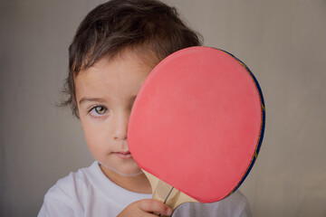 portrait of a little boy playing with ping pong racket